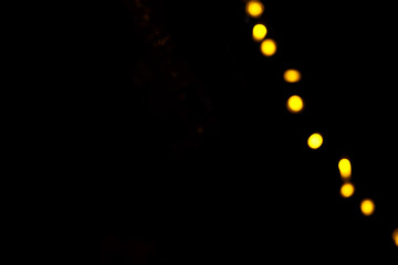 Abstract gold bokeh line on black background. Defocused yellow lights, abstract texture