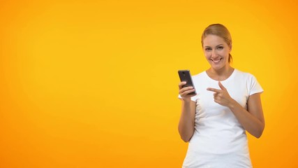 Happy young woman pointing at smartphone hand, easy credit, online application
