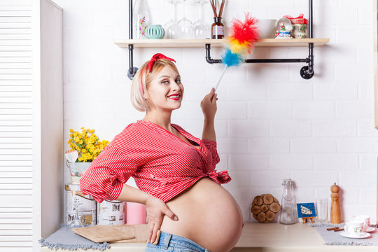 young pregnant woman iinduces cleanliness in the kitchen with pipidaster