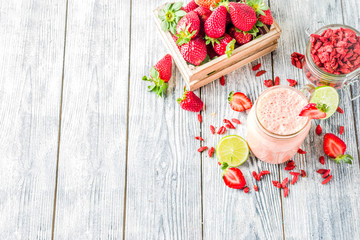 Healthy blended drink. Organic diet smoothie with lime, strawberry and goji berries, wooden...