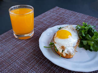 Breakfast of scrambled eggs with greens and strakan orange juice on the table. Breakfast with space for an inscription