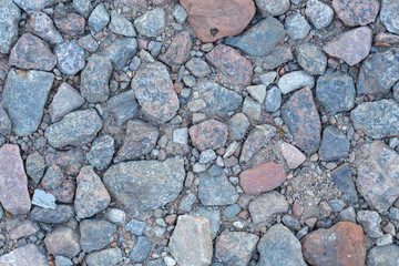 Top view color photography of many stones in soil. 