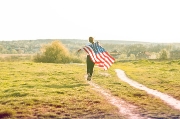 Happy women running in the field with American flag USA celebrate 4th of July