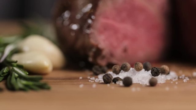 Close-up granules of salt and pepper garlic and rosemary on the background of roast beef. restaurant food. food supply in retsoran. macro food shot