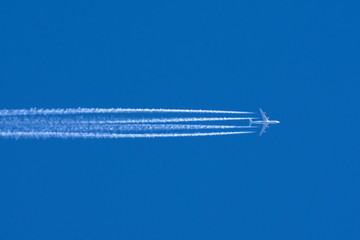 Airplanes leaving contrail trace on a clear blue sky.