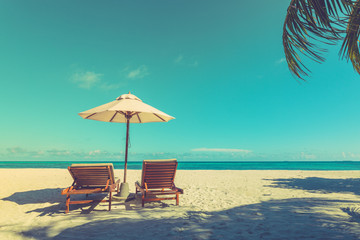 Calm beach scene, vintage toned process, sand and palm leaf under blue sky. Peaceful and inspirational landscape, exotic travel destination background