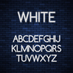 Obraz premium Glowing neon alphabet on brick wall background