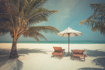 Chairs and umbrella on tropical beach. Luxury travel and vacation background