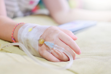 IV solution in a child's patients hand,Close up Children patient's hand recieving iv saline solution in hostpital