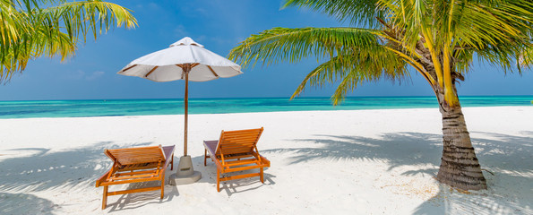 Sunbed and umbrella on a beautiful tropical beach. Summer vacation and holiday concept