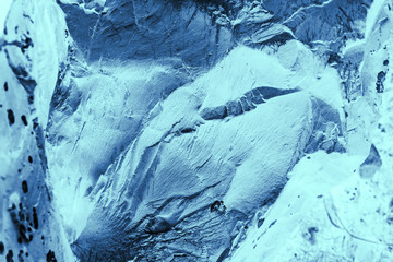 Vintage blue background. Rough painted wall of sapphire color. Imperfect plane of blue colored. Uneven old decorative toned backdrop of cyan tint. Texture of sapphirine hue. Ornamental stony surface.