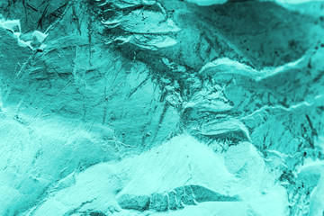 Vintage azure background. Rough painted wall of turquoise color. Imperfect plane of cyan colored. Uneven old decorative toned backdrop of aqzure tint. Texture of teal hue. Ornamental stony surface.
