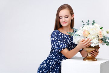 girl in a dress next to the flowers, rejoices, content. On a white background. Spring. Women's Day