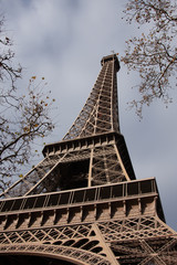 A low perspective of the Eiffel Tower with a blue sky on  an autumn day in Paris France