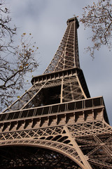 A low perspective of the Eiffel Tower with a blue sky on  an autumn day in Paris France