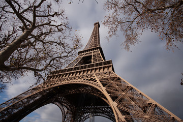 A low perspective of the Eiffel Tower with a blue sky on  an autumn day in Paris France