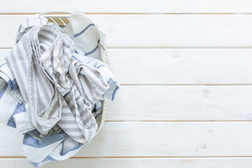 Marie Kondo tidying concept - folded kitchen linens in white basket, top view