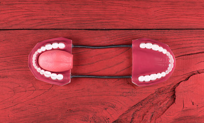 Halloween teeth on a red wooden background