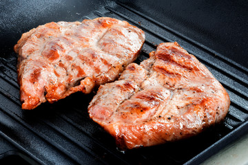 Two Grilled beef steaks on grill pan.