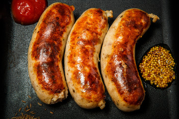 top view macro square pan with three fried sausages