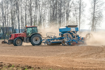 Fototapeta premium Small farm with red tractor and plows in a field