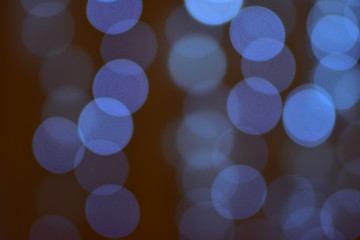 Delicate circles of blue bokeh from elegant festive decorations on a contrasting black background