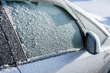 Frozen automotive glass covered with ice and snow
