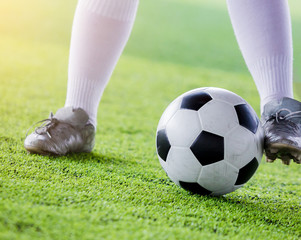 Obraz premium kid soccer player jogging with control ball to shoot to goal on artificial turf.