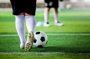 kid soccer player put white sport shoes jogging and control ball go to other players