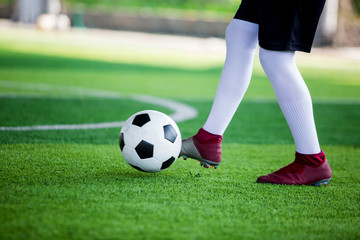 Soccer player speed run to control and shoot ball to goal on artificial turf