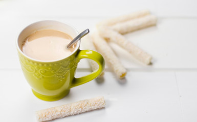  A cup of tea with milk. Green cup. A cup of coffee. A cup of tea with cookies and sweets