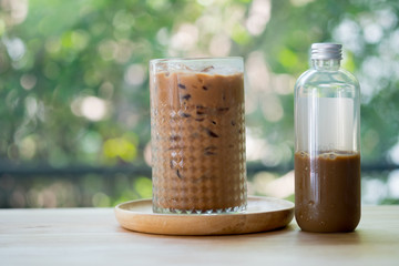 Iced coffee mocha in a tall glass and bottle