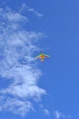 Favorite toy for a child and their parents on vacation is a bright flying kite against a blue sky