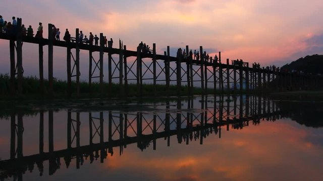 Silhouetted people on U Bein Bridge at sunset, Amarapura, Mandalay region, Myanmar, Lockdown.