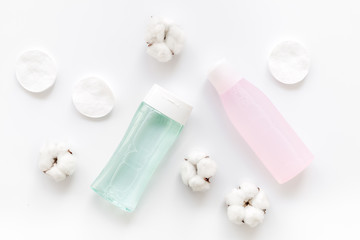 facial tonic, lotion and cotton pads for face care on white background top view mock up