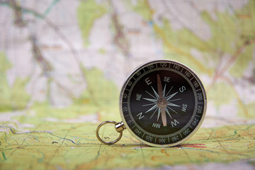 Fototapeta na wymiar Detailed view of compass and tourist map with defocused background