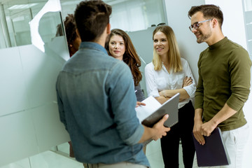 Multiethnic group of young people standing in the modern office and brainstorming