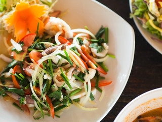 Traditional Thai cuisine. Salad with fresh vegetables and herbs and seafood on a plate in a cafe. Authentic fresh traditional thai food at the restaurant