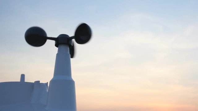 Weather vane wind gauge for direct and strength. sunset color in background., Zoom out.