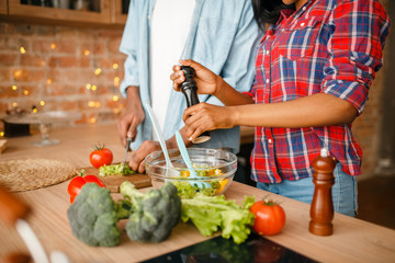 Black couple cooking together on the kitchen