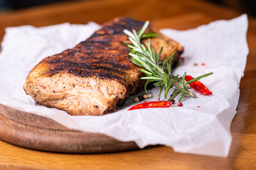 Grilled beef fillet steaks with herbs and spices on wooden background