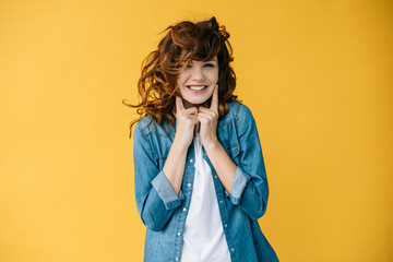 pretty young woman touching cheeks while standing on orange