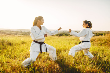 Fototapeta na wymiar Two female karate in kimono training combat skill