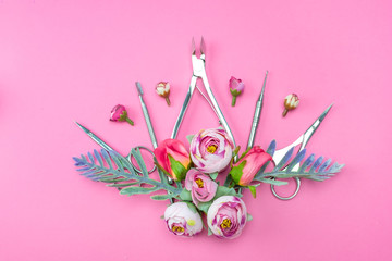 Manicure tools on a pink background decorated with flowers.