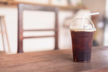 Coffee cup of hot ice americano on wood table in coffee shop background 
