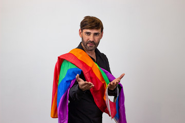 Portrait of handsome young man with gay pride movement LGBT Rainbow flag and brown hair with hate,...