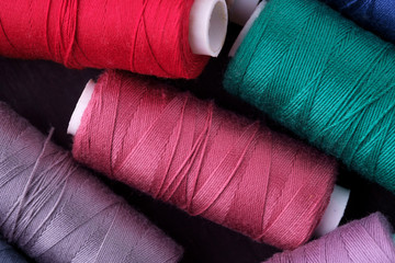 Top view close up of scattered colorful cotton thread coils