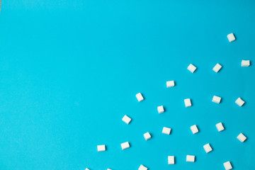 Refined sugar cubes on color background, top view
