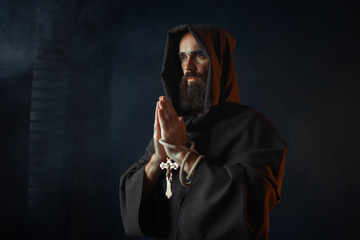 Medieval monk praying with closed eyes - obrazy, fototapety, plakaty