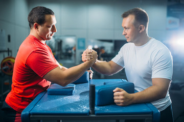 Arm wrestlers prepares for battle at the table